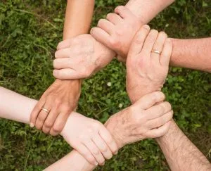 Five people holding each other by the wrists