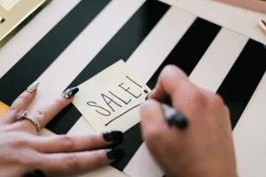woman writing a sale sign