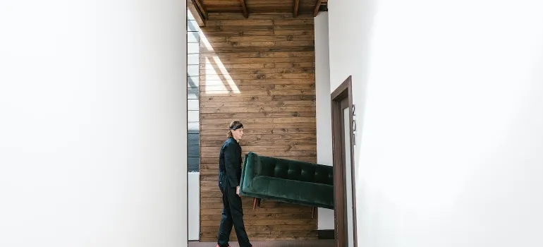 A man carrying a green sofa