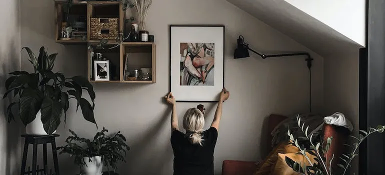 a person hanging a picture