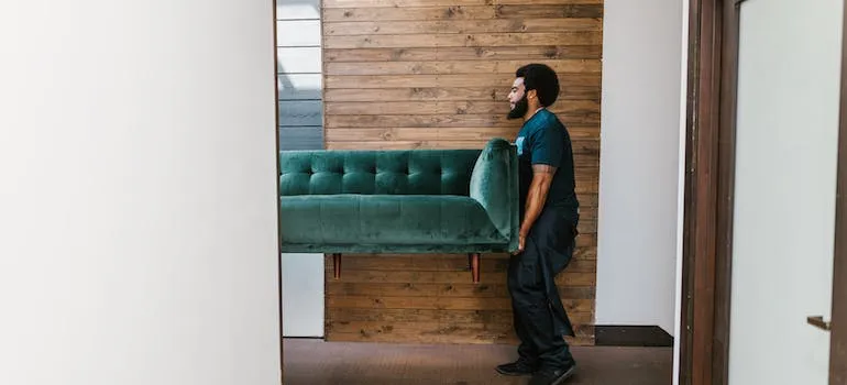 a man carrying a sofa
