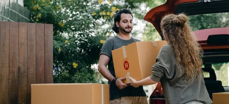Couple passing carton box to each other