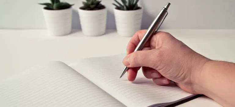 person writing down how to prepare your home for professional movers