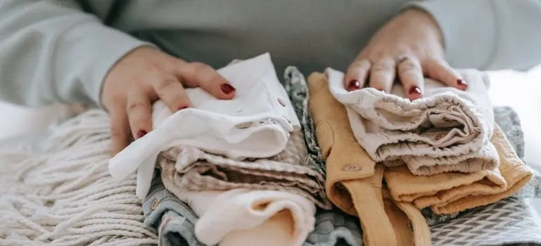 woman with folded clean baby clothes