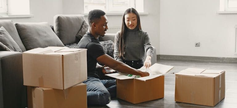 Man and Woman Sitting near Moving Boxes