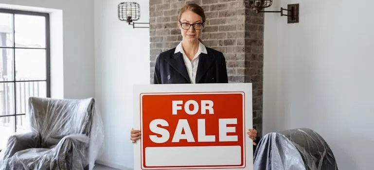 A Real Estate Agent Holding a Sign