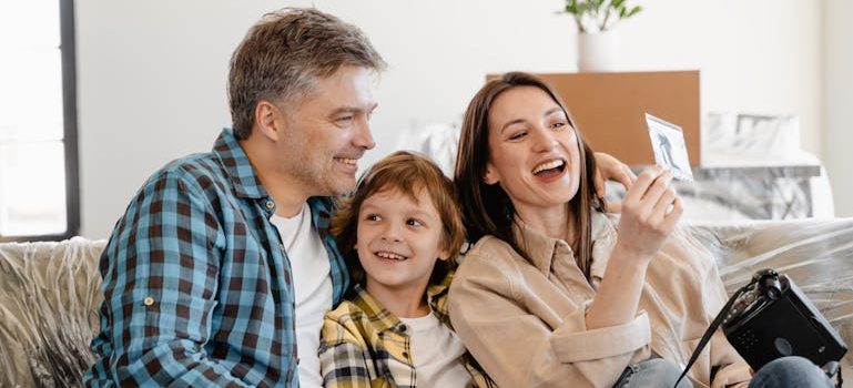 Man and Woman Smiling While Holding White Smartphone