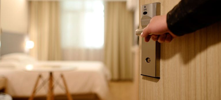 Person Holding on Door Lever Inside Room