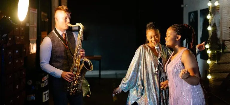 A Man Playing the Saxophone and Women Singing Together