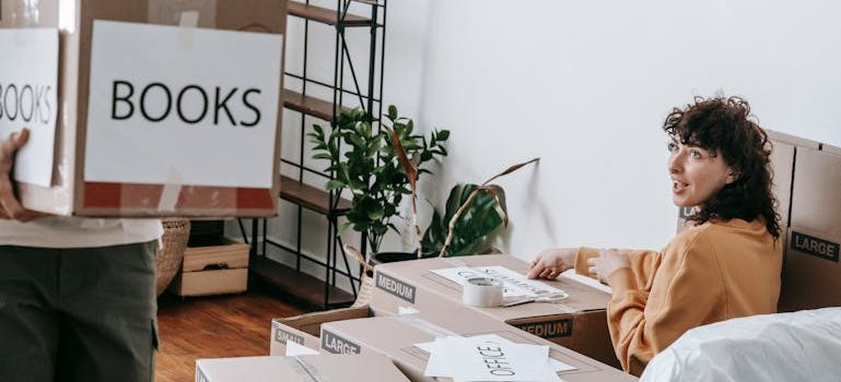Couple Packing Up And Putting Labels On Boxes