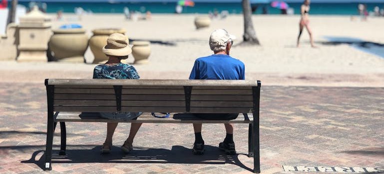 Man and Woman Sitting on Brown Wooden Bench
