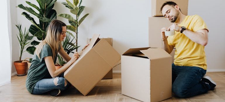 couple packing belongings into carton boxes