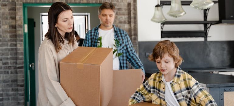 A Newly Moved Family Carrying Cardboard Boxes
