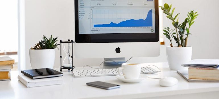 Silver Imac Displaying Line Graph Placed on Desk
