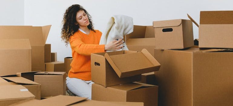 lady packing clothes into boxes during relocating