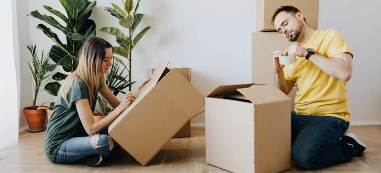 couple packing belongings into carton boxes