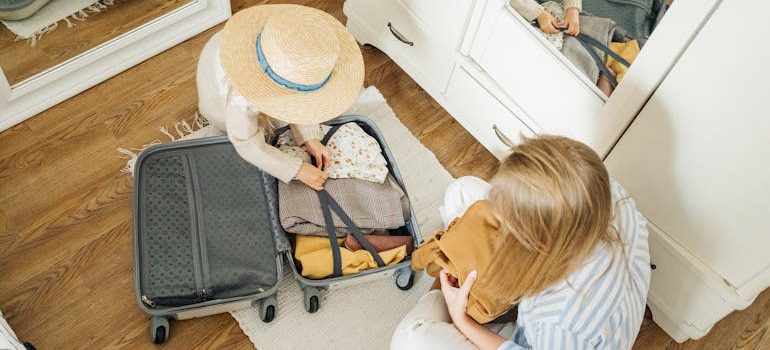 A Woman and a Child Packing a Suitcase