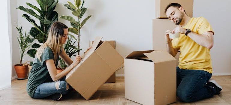 couple packing belongings into carton boxes