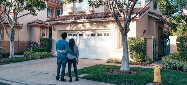 Couple Standing In Front of their House