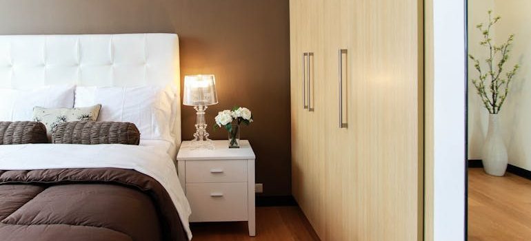 White Bed Next to White Accent Table