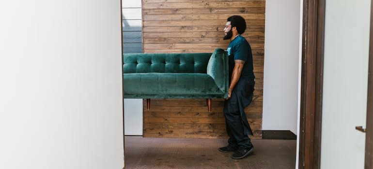 a man carrying a couch
