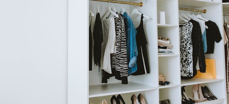 Clothes Hanged on White Wooden Cabinet