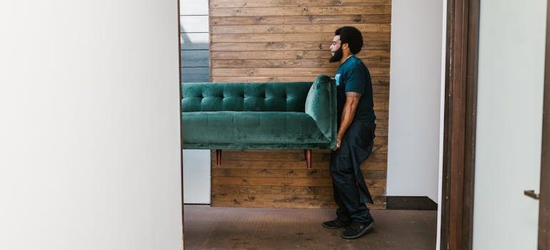 a man carrying a sofa
